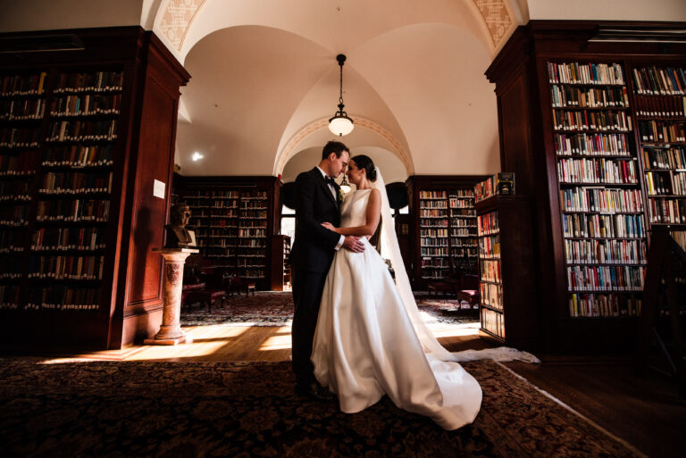 Bride and groom pose in the library of The Union League