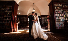 Bride and groom pose in the library of The Union League